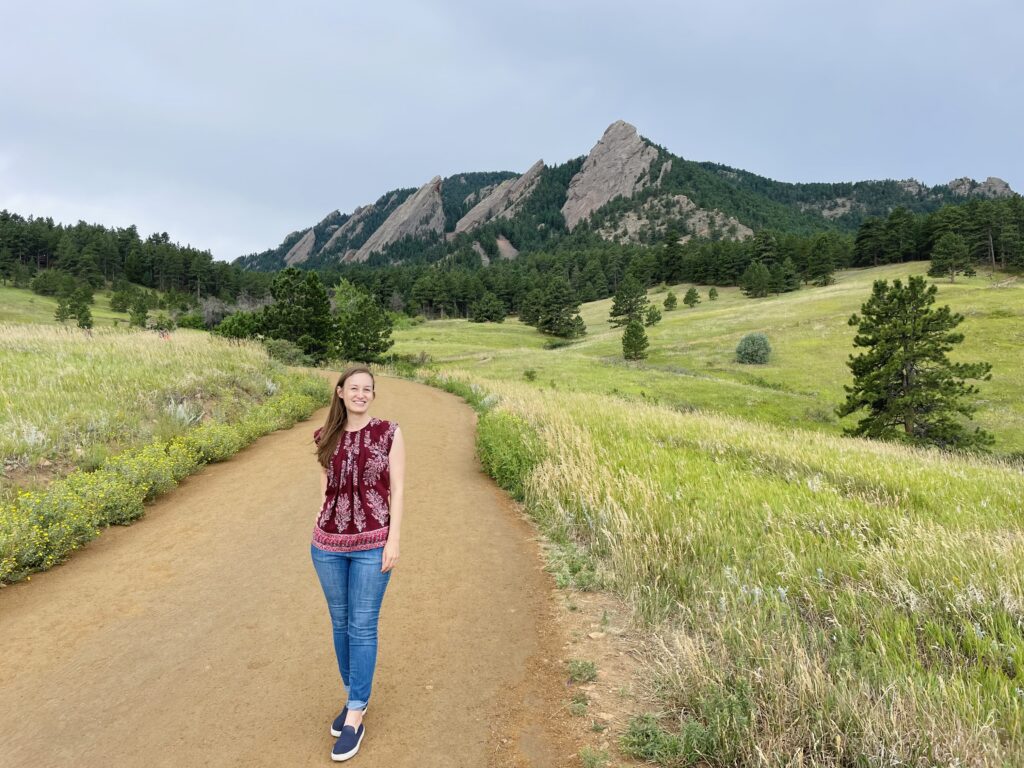 Photo of a woman in front of the Flatiron Mountains on the Chautauqua Trail at Chautauqua Park